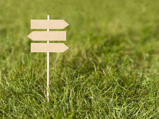Direction sign three ways green grass 