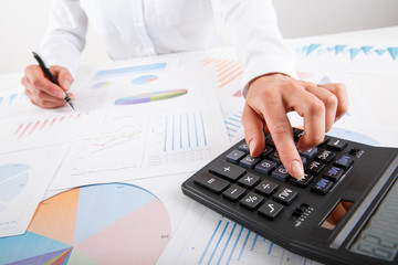 Business woman pointing at graph document close-up.