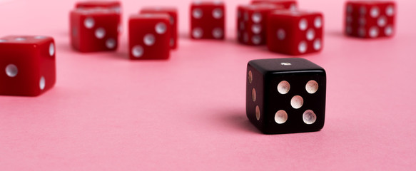Panoramic image red and black gaming dices on pink background