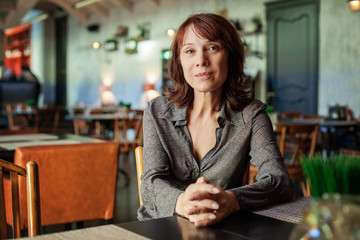 Mature woman sitting in restaurant, portrait