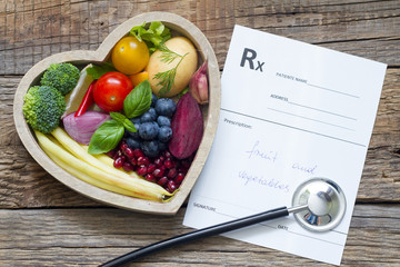 Healthy food in heart stethoscope and medical prescription diet and medicine concept
