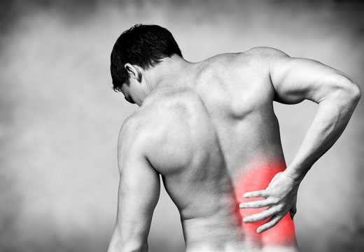 Strong man with back pain, back view
