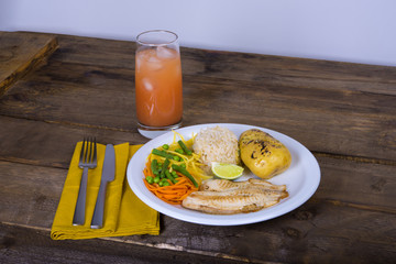 tilapia fillet with baked potato, vegetables, lemon and rice