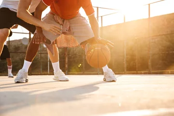  Cropped image of multiethnic men basketball players © Drobot Dean