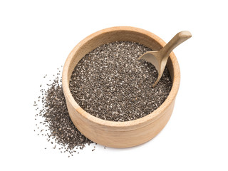 Chia seeds in a wooden bowl and a spoon in it with small pile on the side seen obliquely from above and isolated on white background