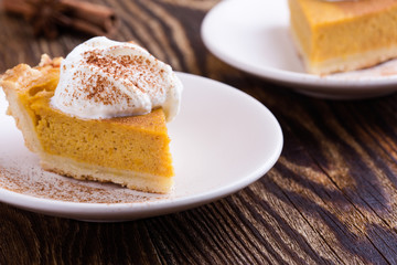Slices of pumpkin pie with whipped cream on top, close-up
