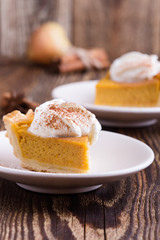 Slices of pumpkin pie with whipped cream on top, close-up