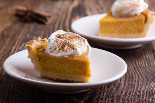 Slices of pumpkin pie with whipped cream on top, close-up