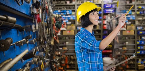 Naklejka premium Composite image of female architect holding clipboard and