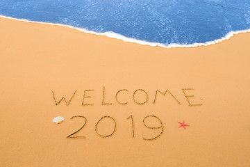 Fototapeta premium welcome 2019 written in the sand on a beach near the coastline