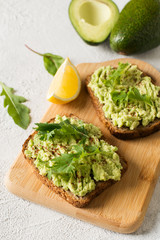 Two toasts with avocado and green salad on breakfast