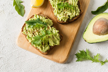 Two toasts with avocado and green salad on breakfast