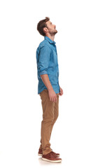 side view of a casual man looking up at something