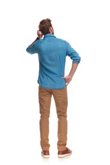 back view of a young casual man scratching his head