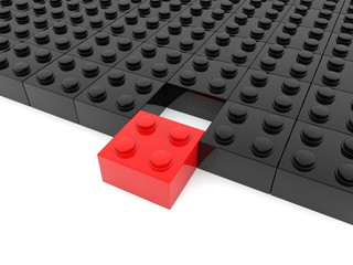 Black toy blocks with a red block in the foreground