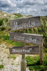 Happily ever after starts here sign on wood in the dunes of Terschelling