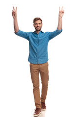 smiling casual man with hands in the air celebrating victory