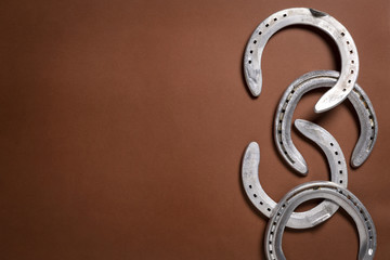 Pile of horseshoes isolated on a brown background