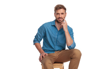  man pushing finger against his cheek in a pensive pose