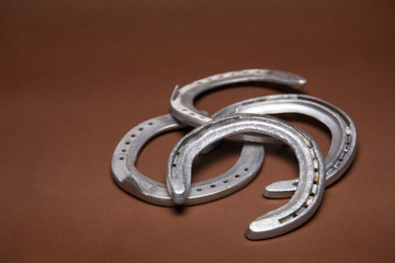 Pile of horseshoes isolated on a brown background
