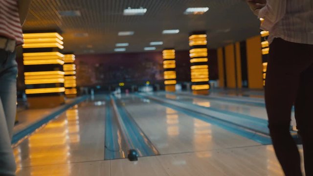 Friends bowling at club and having fun playing casually