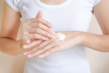Woman applying moisturizing cream/lotion on hands, beauty concept.