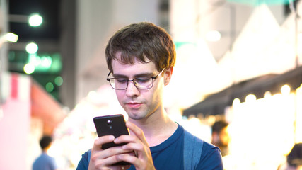 Man Texting Using Smartphone in Busy City