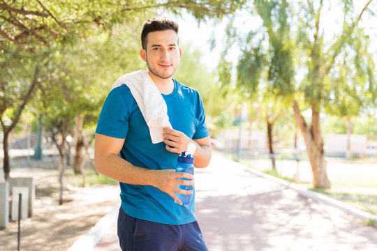 Sportsman With Water Bottle And Towel Standing In Park