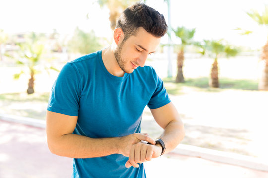 Runner Checking Heart Rate On Smartwatch After Jogging In Park