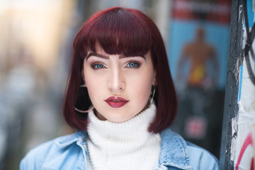 Portrait of young redhead with denim jacket and white turtle neck