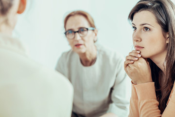 Woman listening to therapist during training for businesswoman in the office