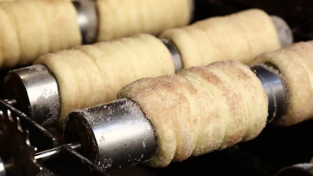 Close up chimney cake baking and rolling