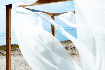 close up view of wooden decoration with white curtain lace, blue cloudy sky and river on background