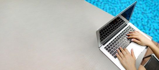 Website banner of laptop with female hands, copy space in grey color and blue background. Concept of blog header and advertisement heading for modern technlogy online shops.