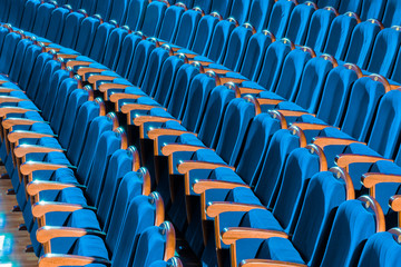 Fototapeta premium Blue plush chairs with wooden armrests in the auditorium. Empty auditorium in the theater.