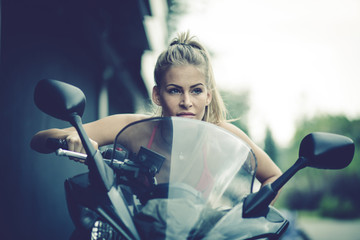 Fototapeta na wymiar Young blonde women ride a motorcycle.