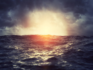Naklejka premium Zachód słońca na wzburzonym morzu