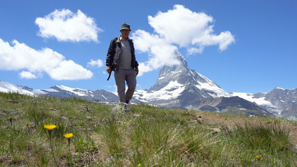 Old Healthy Man Hiking with Mountains in Background