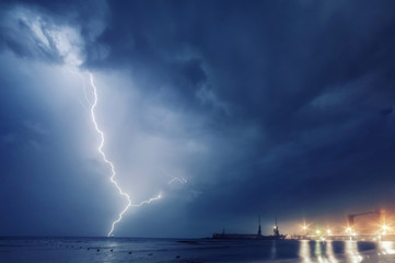 Naklejka na ściany i meble Summer storm, dramatic sky and amazing lightnings over the ocean. natural background
