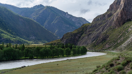River against a backdrop of mountains, forests and sky
