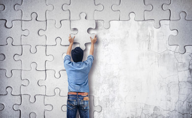 Man making a puzzle on the wall. empty wall with space for text