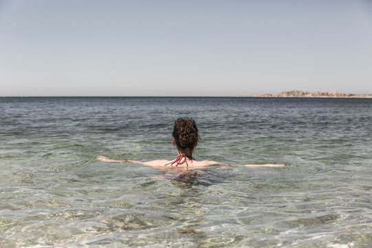 Femme se relaxant en mer et regardant l'horizon