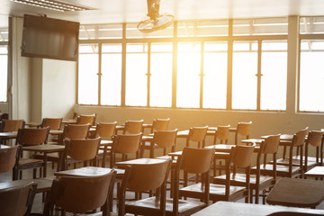 Empty classroom with many wooden chairs