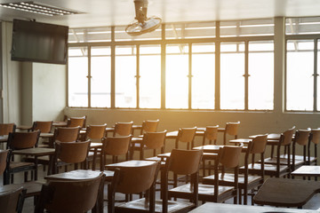Empty classroom with many wooden chairs