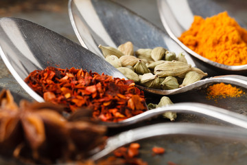 Various spices spoons and herbs on a rustic background