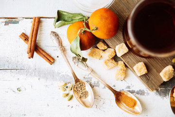 mulled wine in a mug and ingredients for making a drink on a white wooden background, top view