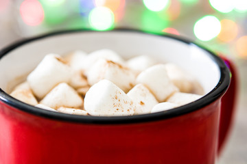 Christmas cocoa with marshmallow and Christmas lights background on wooden table

