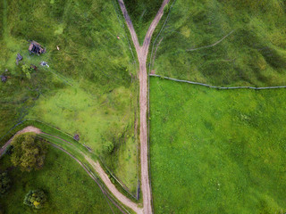 arial veiw of rural road, green field and trees. drone shot