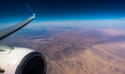 Engine Wing airplane sky concept. View of engine plane from window airplane see wing and sky and desert. It flying over above on desert beauty..