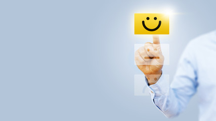 Hand of client show a feedback with smiley face card. Service rating, satisfaction concept